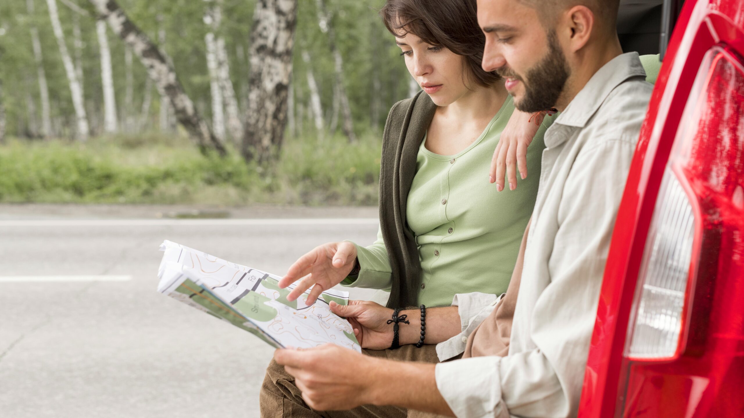 mid-shot-couple-sitting-trunk-looking-map classes